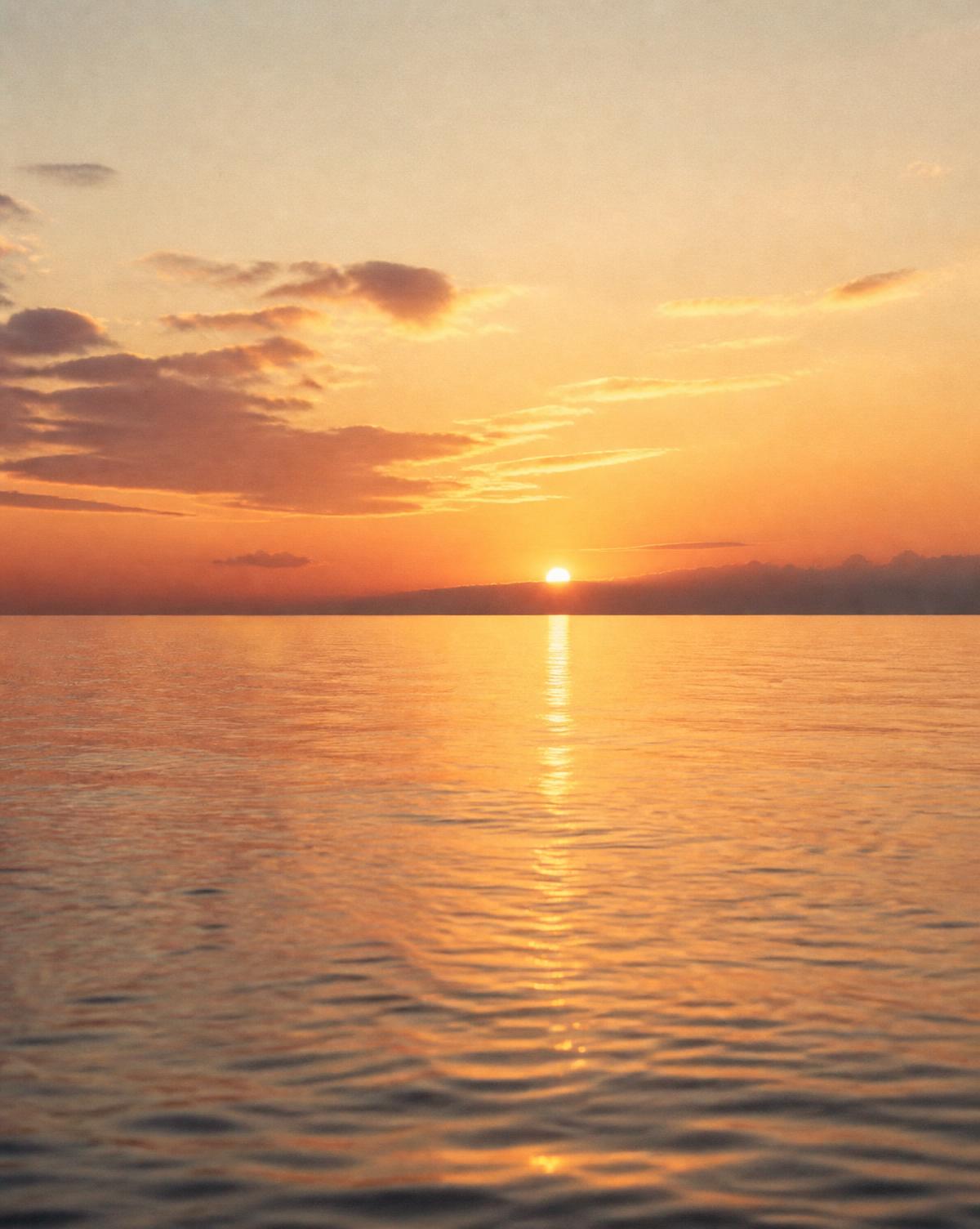 A peaceful sunset over a calm ocean horizon